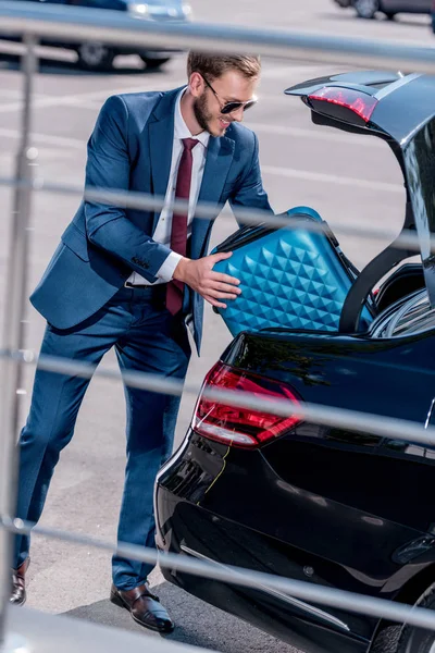 Бизнесмен с чемоданом в машине — стоковое фото