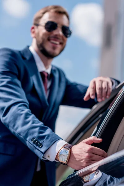 Бизнесмен, стоящий у машины — стоковое фото