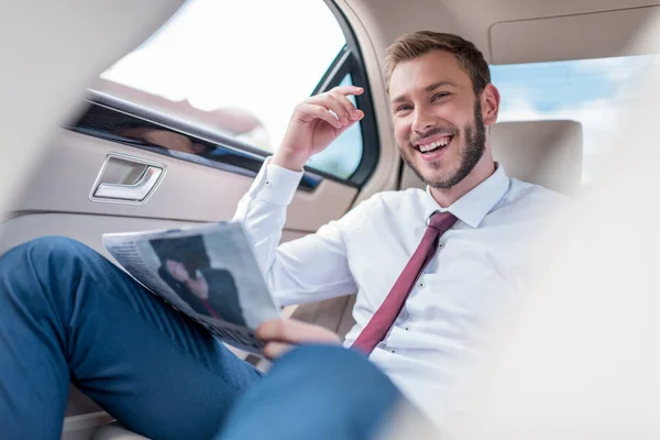 Man with newspaper on backseat — Stock Photo