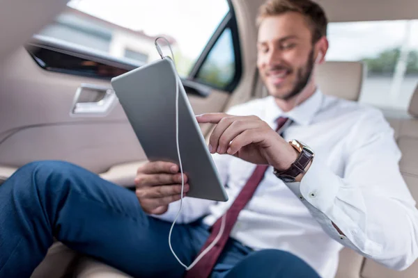 Hombre con tableta digital en el coche - foto de stock