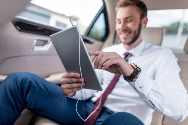 Homem com tablet digital no carro — Fotografia de Stock