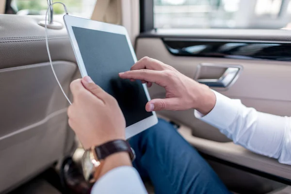 Hombre con tableta digital en el coche - foto de stock