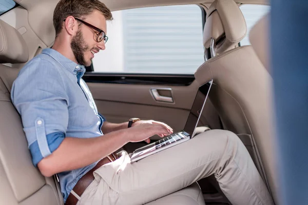 Homem usando laptop no carro — Fotografia de Stock