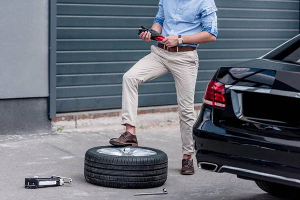 Uomo che cambia pneumatico auto — Foto stock