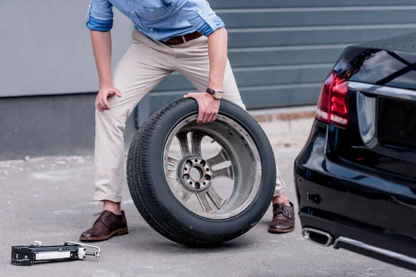 Hombre cambiando neumático de coche - foto de stock