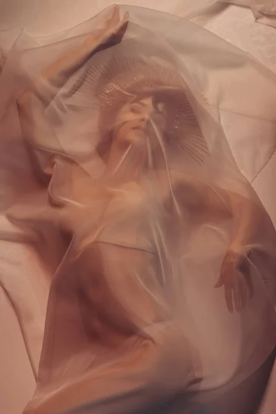 Женщина, лежащая под покрывалом — стоковое фото