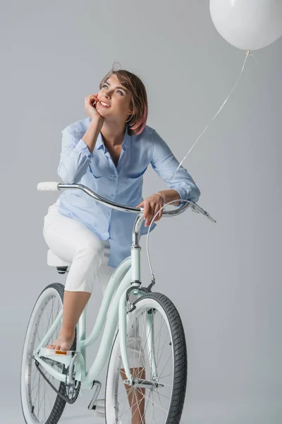 Dreamy girl sitting on bike — Stock Photo