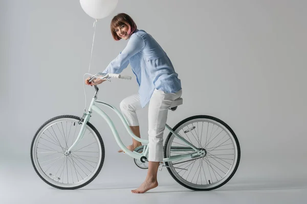 Chica en bicicleta con globo - foto de stock