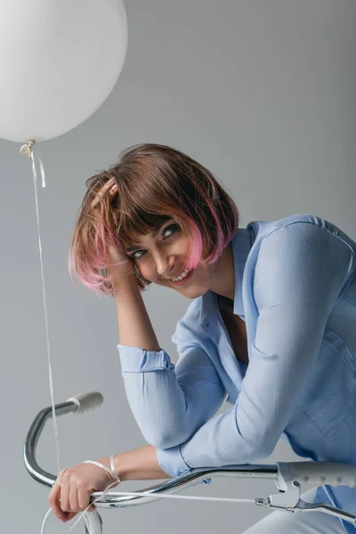 Menina feliz na bicicleta com balão — Fotografia de Stock