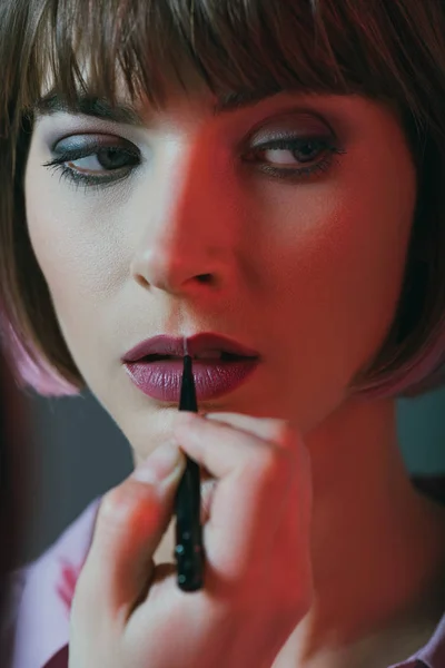 Girl applying lipstick — Stock Photo