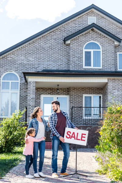 Family standing in front of house on sale — Stock Photo