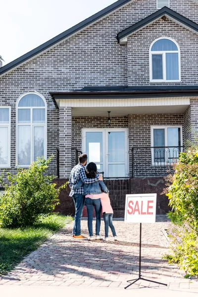 Family looking at house on sale — Stock Photo