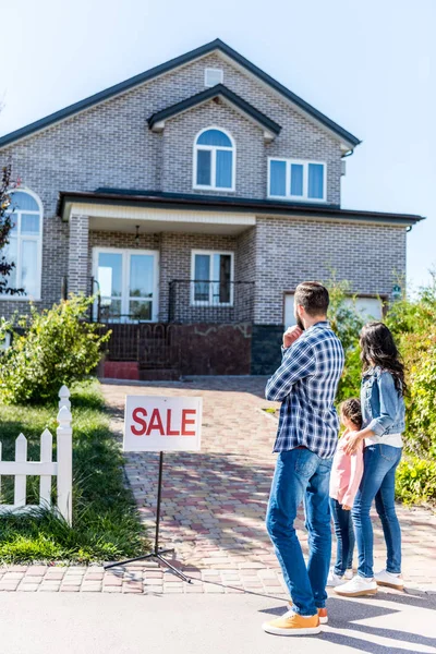 Family looking at house on sale — Stock Photo
