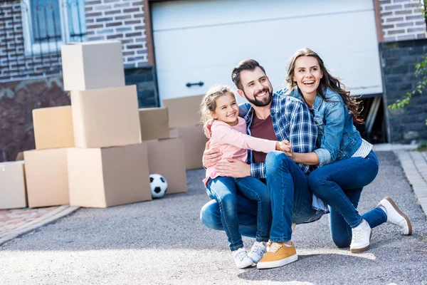 Familia sentada frente a una casa nueva - foto de stock