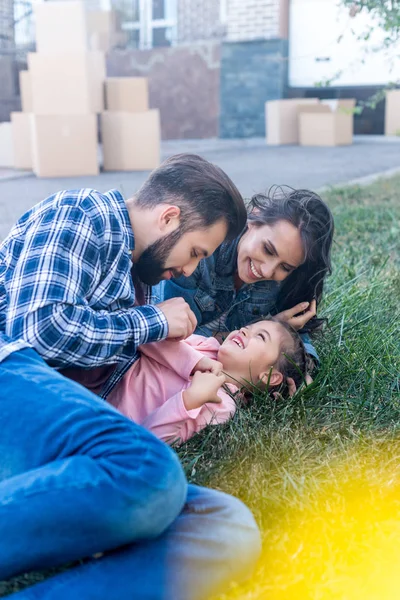 Padres abrazando hija en hierba - foto de stock