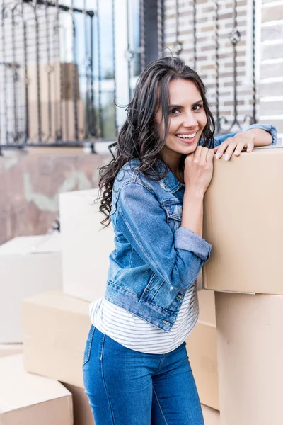 Jeune femme appuyée sur des boîtes — Photo de stock