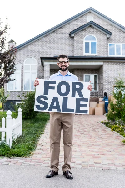 Agente immobiliare con banner in vendita — Foto stock