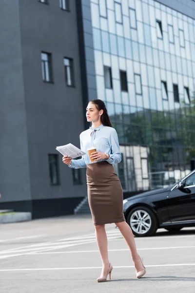 Femme d'affaires tenant journal et café — Photo de stock