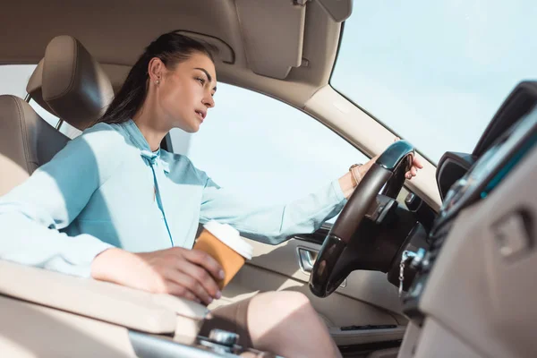 Mulher dirigindo carro com café — Fotografia de Stock