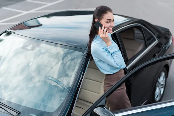 Donna d'affari che parla su smartphone vicino auto — Foto stock