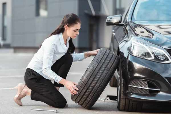 Donna che cambia pneumatico auto — Foto stock