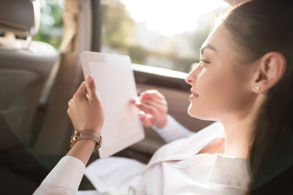 Woman using digital tablet in car — Stock Photo
