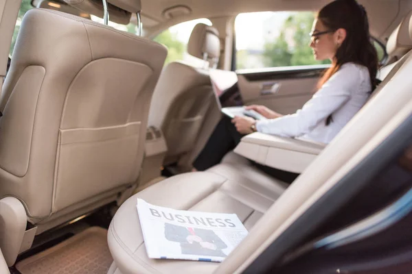 Jornal de negócios no banco de trás do carro — Fotografia de Stock