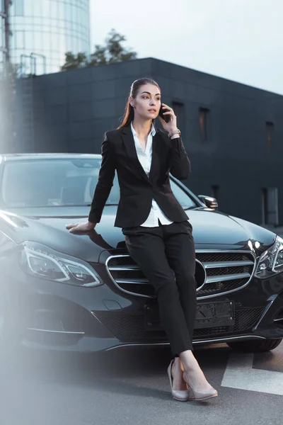 Женщина, сидящая на машине и разговаривающая по телефону — стоковое фото