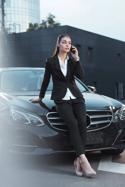 Femme assise en voiture et parlant au téléphone — Photo de stock