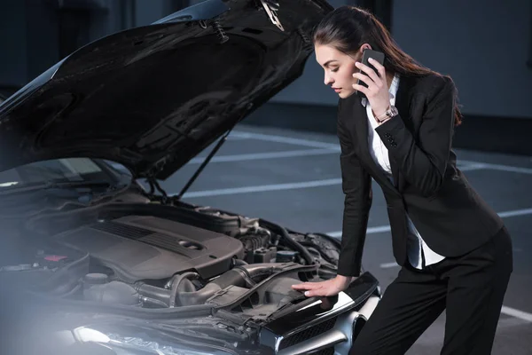 Mulher olhando sob o capô do carro — Fotografia de Stock