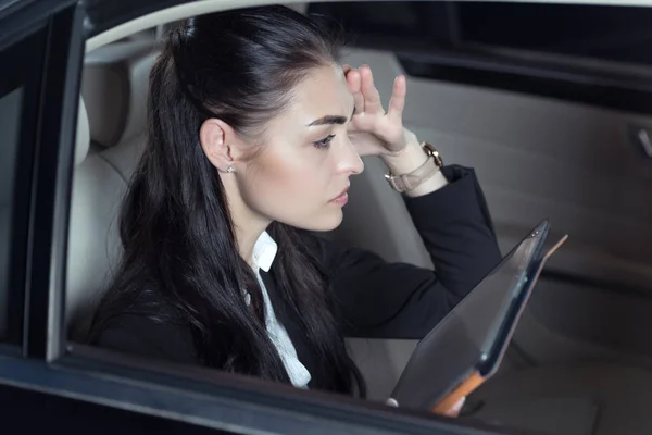 Женщина в машине с цифровым планшетом — стоковое фото