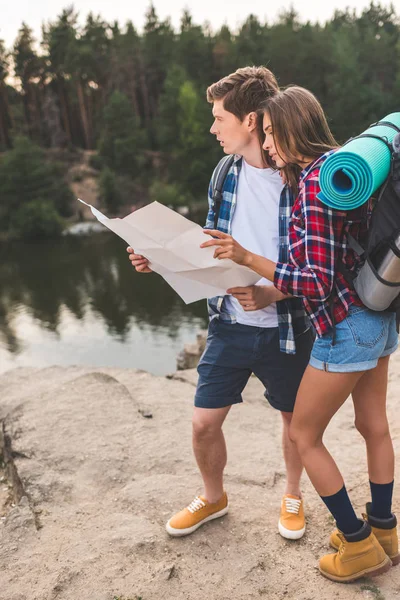 Couple of hikers with map — Stock Photo
