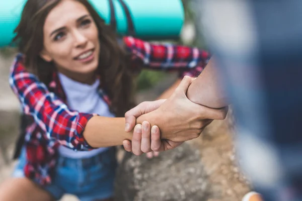 Hombre ayudando novia a subir roca - foto de stock