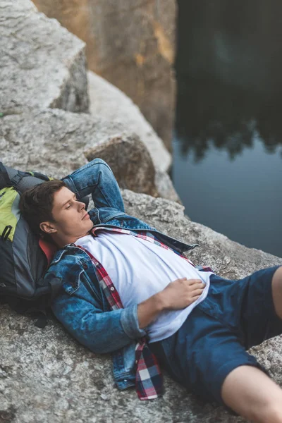 Hiker relaxing on river shore — Stock Photo