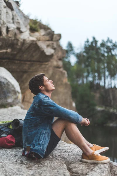 Junger Mann entspannt sich auf Klippe — Stockfoto