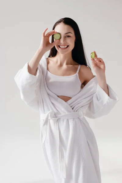 Smiling woman holding slices of cucumber — Stock Photo