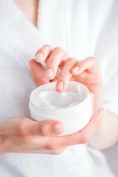 Woman holding face cream jar — Stock Photo