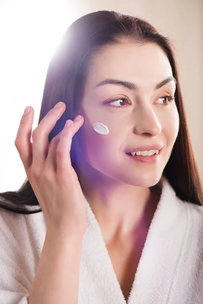 Mulher aplicando creme facial — Fotografia de Stock