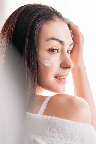 Young woman with cream applied to face — Stock Photo