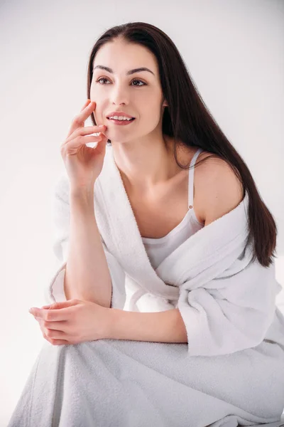 Attractive woman in bathrobe posing on chair — Stock Photo