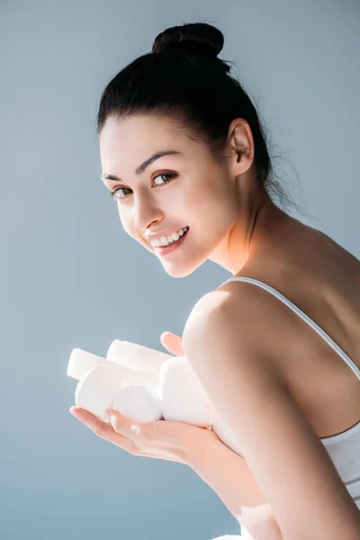 Mujer sonriente sosteniendo recipientes cosméticos - foto de stock