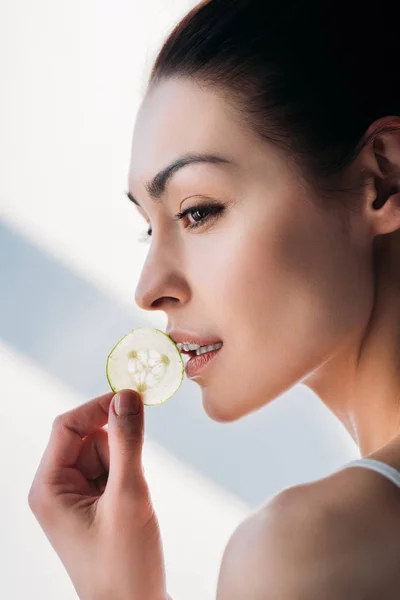 Donna che mangia fetta di cetriolo — Foto stock