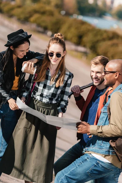 Multikulturelle Freunde wählen das Reiseziel auf der Karte — Stockfoto