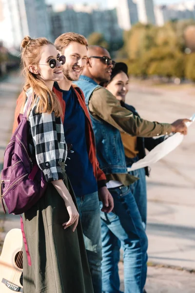 Multicultural friends with map — Stock Photo