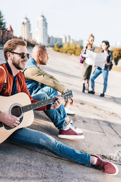 Multicultural friends with guitar — Stock Photo