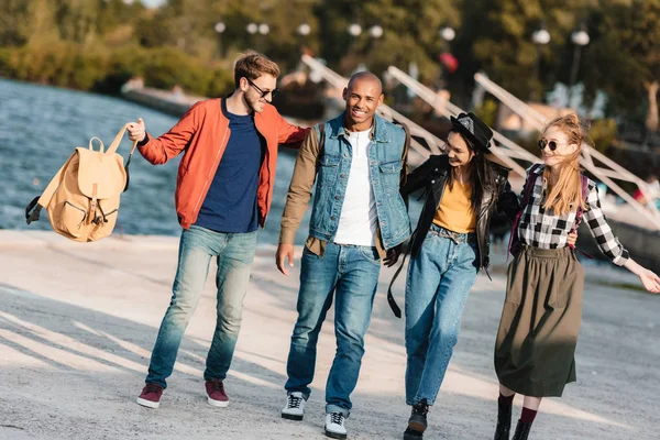 Amigos multiculturales caminando en el muelle - foto de stock