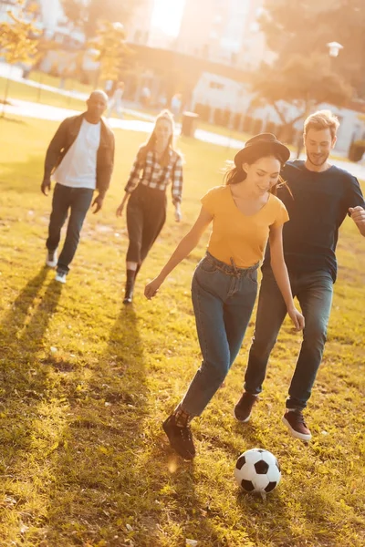 Multicultural friends playing soccer — Stock Photo