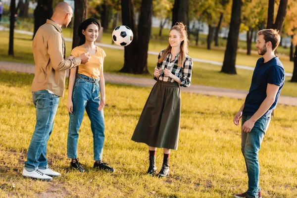 Amigos multiculturales con pelota de fútbol - foto de stock