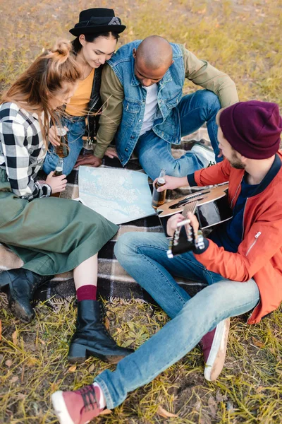 Amigos multiculturales con mapa en el parque - foto de stock