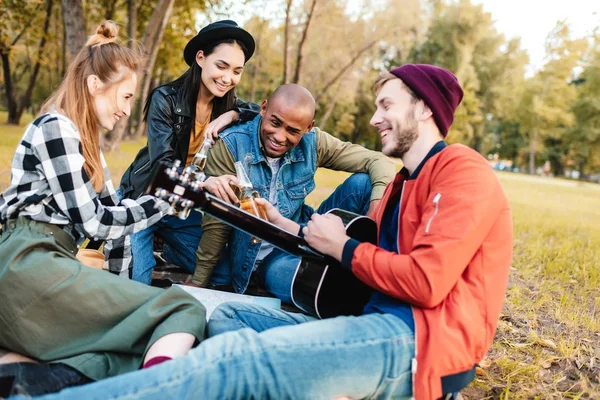 Multicultural friends resting in park — Stock Photo